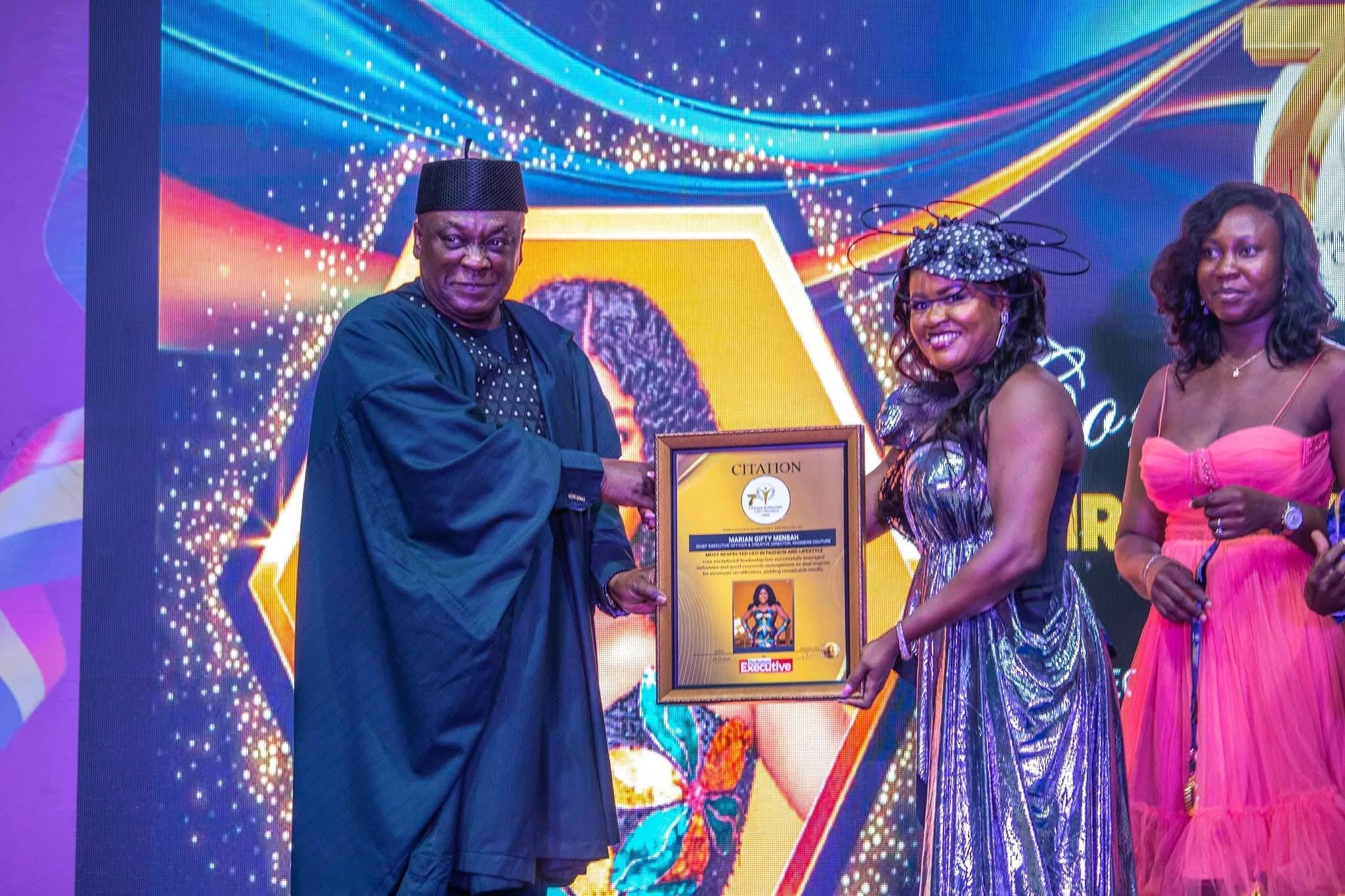 Three people presenting an award on stage, similar to award-citation-2026 but a different photograph from the same WhatsApp share.