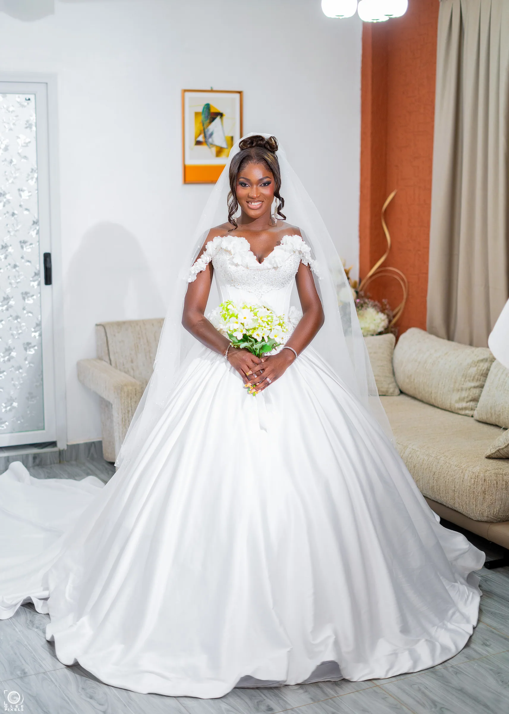 Full-length view of a bespoke ivory Magmens Couture ball gown with a fitted corseted bodice, worn with a long tulle veil.